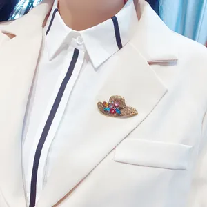 Close-up of a vintage rhinestone hat brooch pinned on a white blazer lapel for fashion