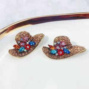 Macro detail of creative vintage hat-shaped brooches with sparkling colorful rhinestones.
