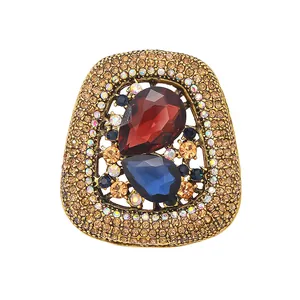 Luxurious vintage crystal brooch featuring red and blue teardrop stones in a gold frame