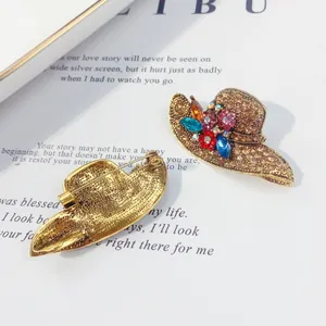 Vintage hat-shaped brooch with colorful sparkling rhinestones and gold-tone metal back.