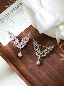 Detailed view of elegant pink crystal angel wing brooch with teardrop pendant