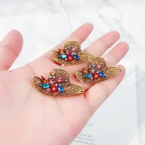 Elegant vintage gold-tone hat brooches with colorful rhinestones shown on hand