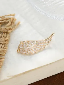 Detailansicht einer eleganten goldfarbenen Ginkgo-Brosche mit funkelnden Strasssteinen.