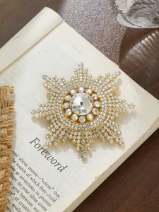Exquisite Sonnenblumen-Brosche mit Strasssteinen auf einer alten Buchseite präsentiert.