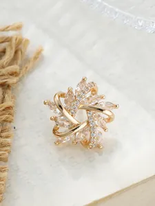 Detailansicht einer eleganten goldenen Blumenbrosche mit funkelnden Marquise-Kristallen