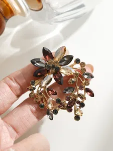Detailansicht einer eleganten Blumenkranz-Brosche mit funkelnden bunten Kristallen
