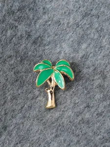 Nahaufnahme einer hawaiianischen Emaille-Palmenbrosche mit grünen Blättern und Goldstamm.