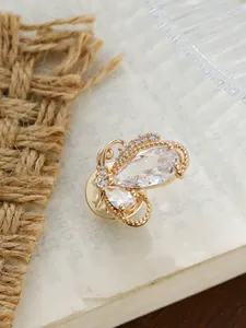 Detailansicht einer goldenen Schmetterlingsbrosche mit funkelnden Kristallen im Vintage-Stil