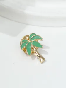 Nahaufnahme einer Brosche in Form einer Kokospalme mit grüner Emaille und Gold-Finish