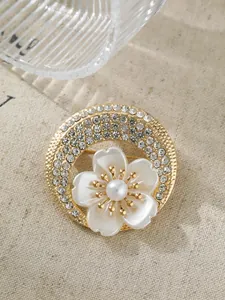 Detailansicht der eleganten Blumenbrosche mit funkelnden Kristallen und einer zentralen Perle