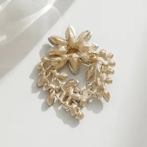 Eleganter goldener Blumenkranz-Brosche mit Steinchen, Rückseite mit Nadelverschluss.