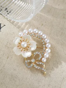 Detailansicht einer eleganten Blumenbrosche mit Perlen und Kristallen auf Leinenstoff