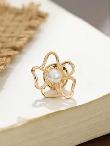 Nahaufnahme einer eleganten goldenen Kamelienblüten-Brosche mit Perlendetail in der Mitte