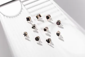 Vista detallada de varios lindos pines decorativos de esmalte negro con toques dorados