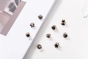 Primer plano detallado de varios mini pines de esmalte negro y dorado para decoración