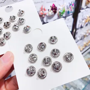 Close-up of silver metal butterfly clutch pin backs for anti-exposure brooch fasteners