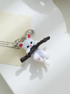 Gedetailleerde weergave van een schattige 3D-harsbroche met een witte kat aan een tak