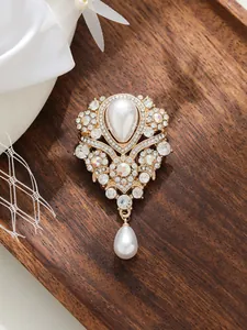 Détail exquis d'une broche vintage française avec perle goutte et strass élégants