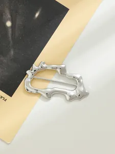 Vista macro dettagliata di una fibbia decorativa in lega d'argento irregolare per cappotti
