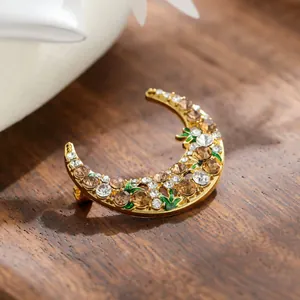 Exquisite crescent moon brooch with glittering rhinestones and green enamel details