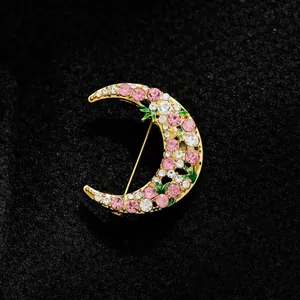 Elegant crescent moon brooch featuring sparkling pink and clear crystals on gold-tone metal.