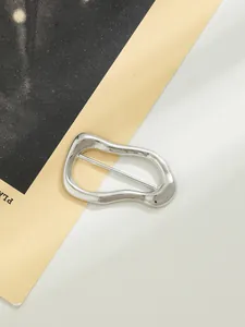 Dettaglio ravvicinato della forma irregolare ondulata di questa fibbia decorativa in lega d'argento.