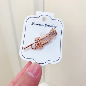 Rose gold trumpet brooch with sparkling rhinestones on jewelry display card