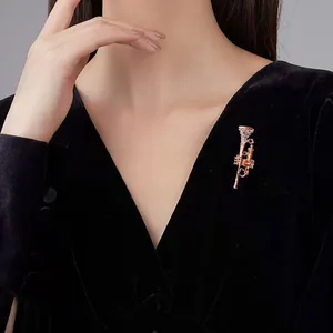 Detailed view of an elegant gold saxophone brooch with crystal accents on black velvet