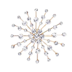 Macro view of an elegant gold snowflake brooch featuring radiant clear rhinestone details