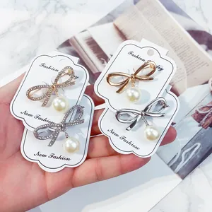 Elegante set di quattro spille a fiocco con perle su cartoncini per gioielli di moda bianchi