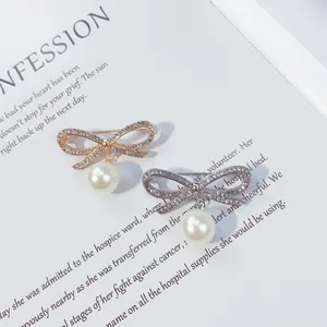 Dettaglio di eleganti spille a fiocco con perle e strass scintillanti.