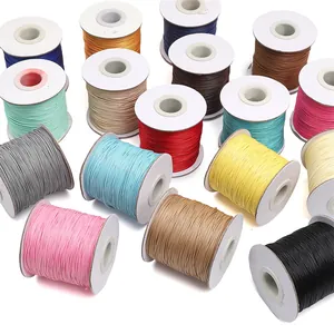 Close-up view of colorful waxed polyester cords in various spools for jewelry making