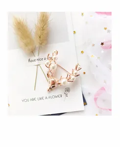 Detailed view of a rose gold deer head brooch decorated with elegant white pearls