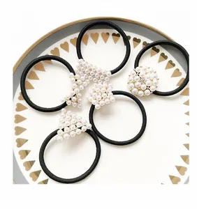 Close-up of elegant pearl and rhinestone hair elastics on a decorative plate