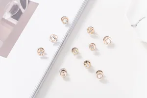 Primer plano de broches decorativos de oro rosa con cristales brillantes en estilo plano