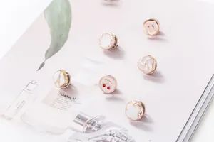 Vista macro de varios lindos broches de esmalte en oro rosa para decoración de ropa