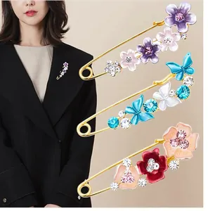 Elegante Blumen- und Schmetterlings-Broschen als Sicherheitsnadel im Detailansicht.