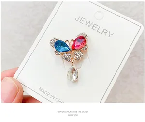 Detail shot of sparkling butterfly brooch with blue and pink crystals