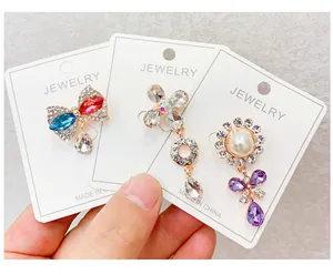 Detailed view of three elegant decorative crystal brooches displayed on jewelry cards