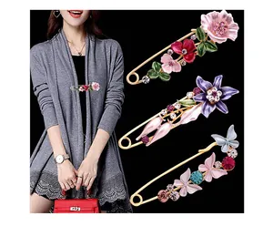 Elegante Sicherheitsnadeln mit Blumen- und Schmetterlingsdekor auf Strickjacke