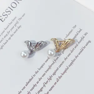 Dettaglio macro di eleganti spille di perle in oro e argento su una pagina di libro