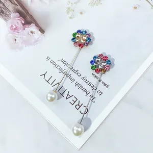 Nahaufnahme von bunten Strassblumen- und Perlen-Anstecknadeln auf Magazin-Hintergrund