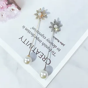 Detailansicht von Blumen-Anstecknadeln mit Strass und Perlen auf weißem Magazin-Hintergrund