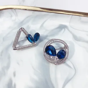 Detailansicht der geometrischen silbernen Broschen mit blauen birnenförmigen Kristallen