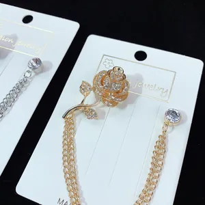 Detailansicht einer eleganten goldenen Rosenbrosche mit Kristallen und Doppelkette