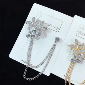 Elegante silberne Blumenbrosche mit funkelnden Strass-Quastenketten in Nahaufnahme