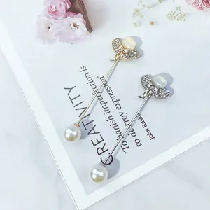 Nahaufnahme von eleganten Gold- und Silber-Perlennadeln mit Strassdetails