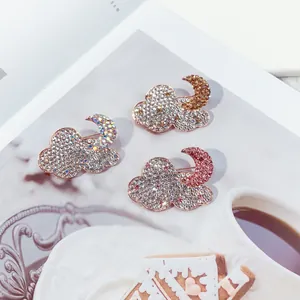 Set of three colorful rhinestone cloud and moon brooches in iridescent, gold, and pink