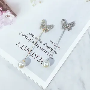 Makro-Detail von Schmetterlings-Anstecknadeln mit Strass und Perlen auf Kunstbuch