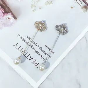 Elegantes Detail von Kronen-Anstecknadeln in Gold und Silber mit Strass und Perlen